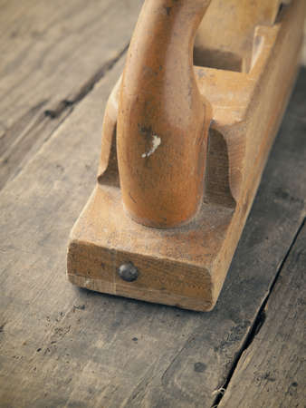 Old used wood plane on a rustic workbench, vintage color style