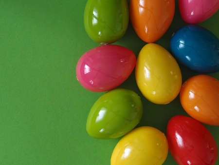 Colorful plastic Easter eggs on a paper background with space for text