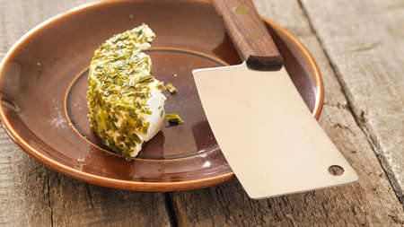 Fresh cheese with chives on a rustic ceramic plate