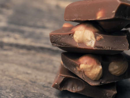 Close up of stacked chocolate bars on a wooden table, vintage color tonedの写真素材