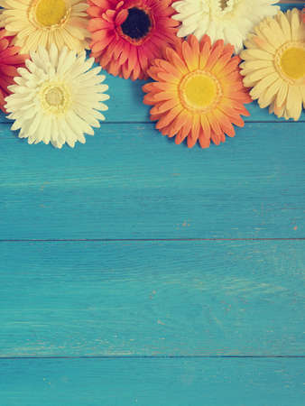 Colorful flower decoration on a blue wooden background with space for text or imageの写真素材