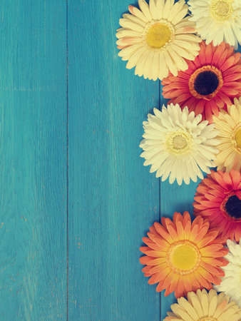 Colorful flower decoration on a blue wooden background with space for text or imageの写真素材