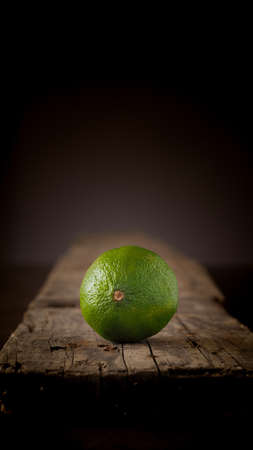 Fresh organic lime fruit on a rustic wooden boardの写真素材
