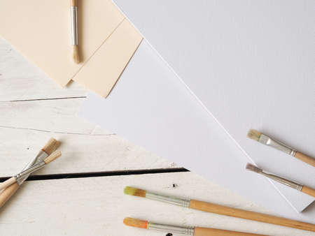 Brushes with paper sheets on a wooden background, creativity backgroundの写真素材