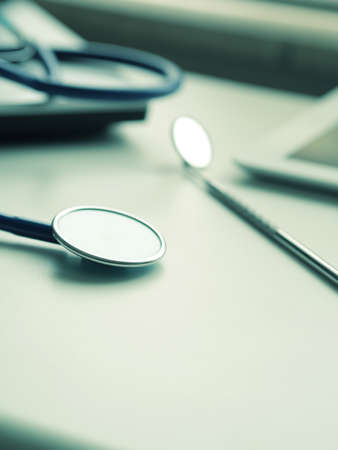 Medical utensils with laptop and tablet computer on a doctor's desk, close up shot with selective focusの写真素材