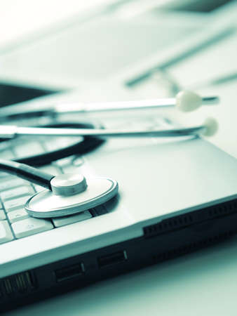 Medical utensils with laptop and tablet computer on a doctor's desk, close up shot with selective focusの写真素材