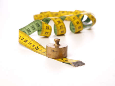 Diet or weight gain concept image with a measuring tabe, isolated on whiteの写真素材