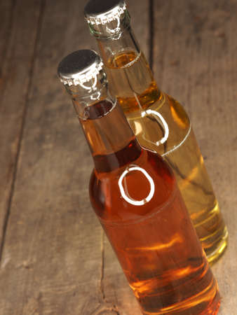 Two bottles of apple juice on an old rustic barn wood backgroundの写真素材