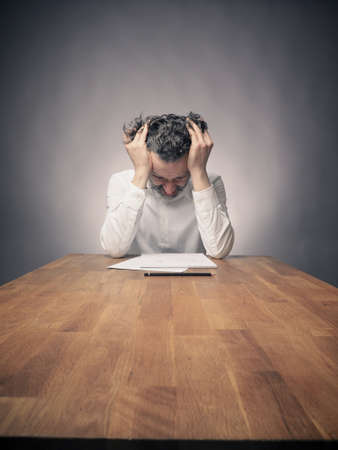 Crazy business man working on a wooden office table, wide angle shot with space for text or image