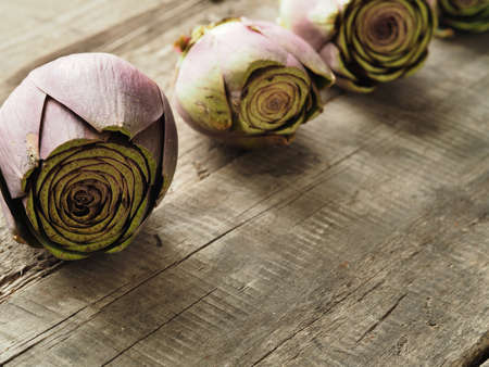 Healthy food concept with organic artichoke on a rustic wooden table, natural light with selective focusの写真素材