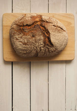 Tasty bread on a rustic wooden background with space for text, view from aboveの写真素材