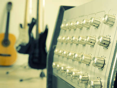 Close up of a vintage amplifier with three guitars in a studio, retro film tonedの写真素材