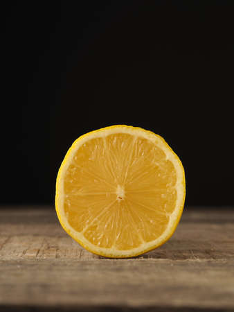 Half organic lemon fruit on a rustic wooden table with space for textの写真素材