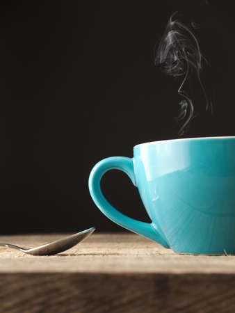 Blue cup of coffee on a rustic wooden tableの写真素材