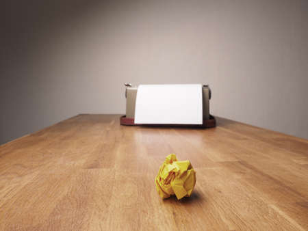 Crumpled paper with an old typewriter on a wooden office desk, creativity concept