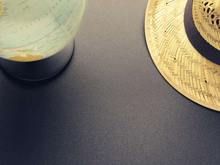 Travel or vacation concept with a straw hat and a retro globe, space for text or imageの写真素材