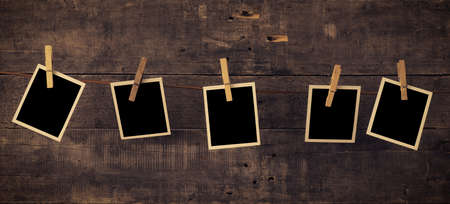 Five old photo frames on a rustic wooden wallの写真素材