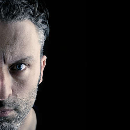 Sceptical man on a black background with space for textの写真素材