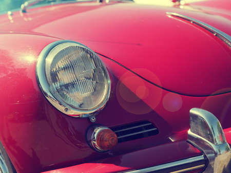 Vintage or retro stylized summer background with an old red sports car