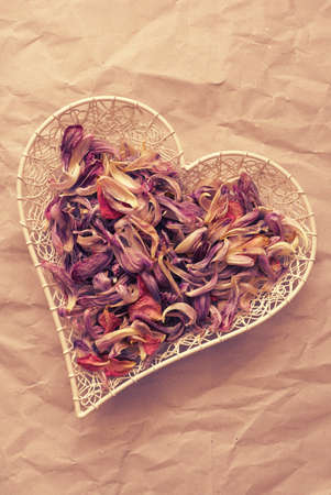 Heart shaped bowl with purple petals, romantic love concept backgroundの写真素材
