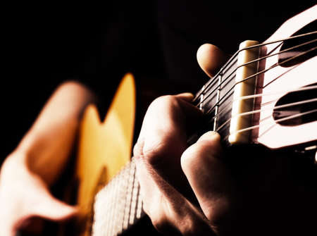 Flamenco guitar player close up, playing traditional acoustic guitar concept image us as background,...
