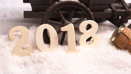 New Years concept background with a wooden number 2018 and a champagne bottle cork in snowの写真素材