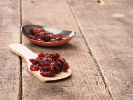 Delicious dried cranberries on a rustic wooden table, healthy food conceptの写真素材