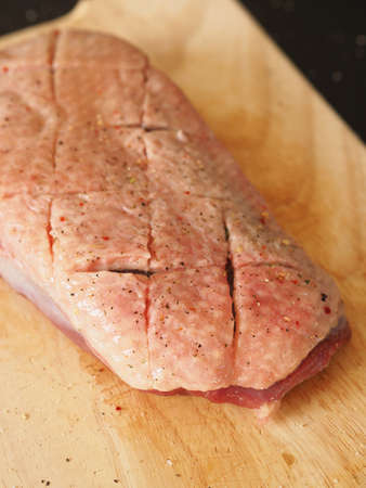 Raw goose breast on a wooden cutting board in a kitchen, Seasonal food, Christmas foodの写真素材