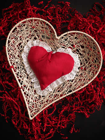 Red fabric heart shape on red shredded paper, love concepts Valentines Day or Mothers Day backgroundの写真素材
