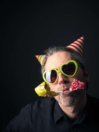 Carnival or birthday conceptual portrait of a man on a dark background