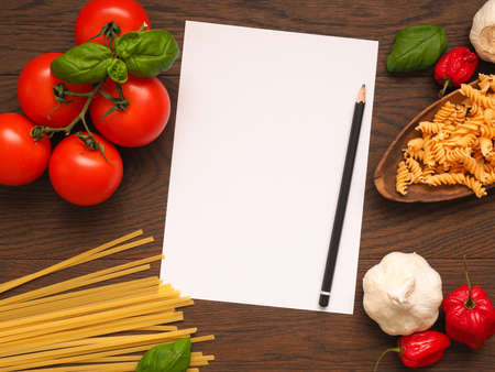 Pasta or Italian food concept background with an empty paper sheet and pencil on a wooden table