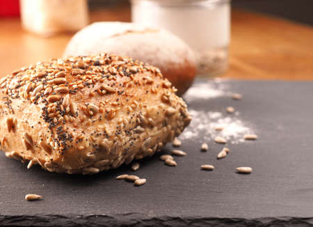 Tasty organic rolls on a dark slate cutting board, natural healthy eatingの写真素材