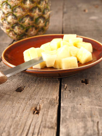 Sweet organic pineapple on a rustic wooden tableの写真素材