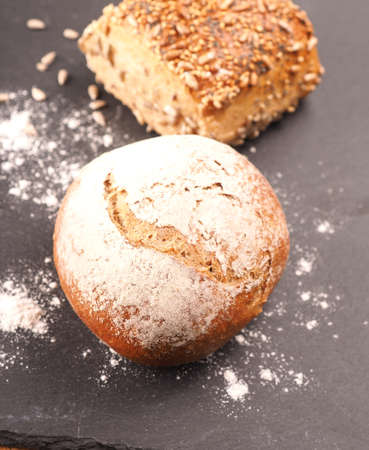 Tasty organic rolls on a dark slate cutting board, natural healthy eating