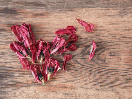 Heart shape of dried tulips petals on a rustic wooden table using as backgroundの写真素材