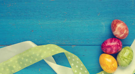 Colorful Easter eggs with decoration on a blue wooden background with space for text or imageの写真素材