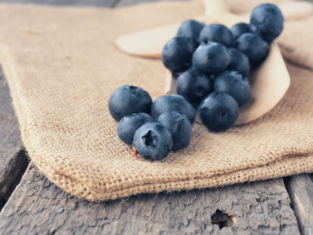 Fresh blueberries on a wooden spoon, healthy eating or food background