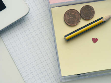Sticky notes with a small pencil and heart shape on an office tableの写真素材