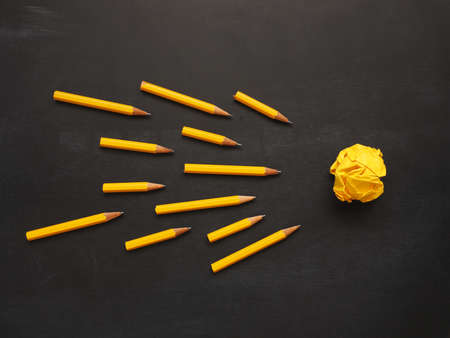 Pencils with yellow crumpled paper on a chalkboard, abstract business or creativity concept