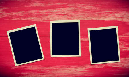 Vintage photo frames on a rustic red wooden backgroundの写真素材