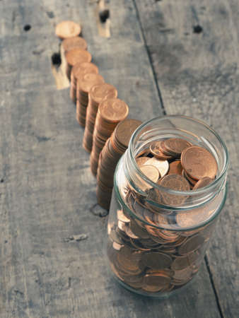 Get rich, stacked coins on a wooden tableの写真素材