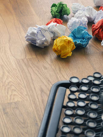 Crumpled paper with an old typewriter on a wooden office table, creativity concept