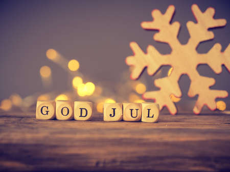 God Jul, Scandinavian Merry Christmas on wooden dices with blurred lights and decorationの写真素材