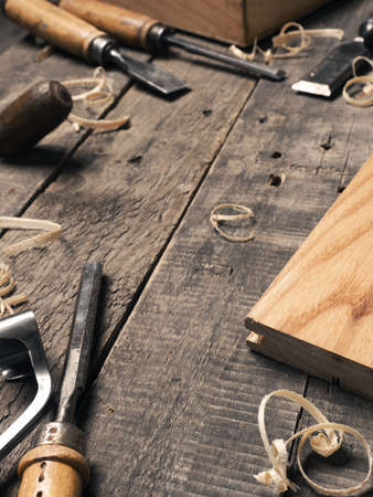 Carpenter tools on a rustic wooden background with space for text
