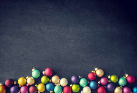 Colorful Christmas baubles on a chalkboard with space for textの写真素材