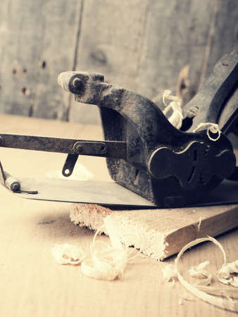 Old used wood plane on a work bench using as traditional wood working backgroundの写真素材