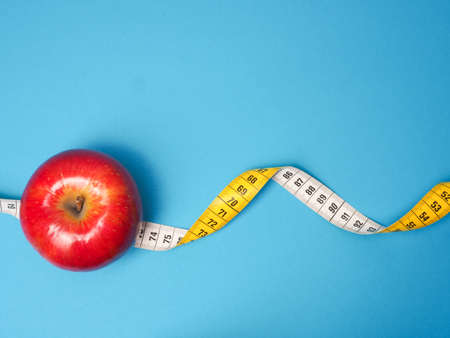 Diet or healthy eating concept with a measuring tapeの写真素材