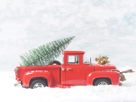 Red vintage pickup truck with a Christmas tree in winter landscapeの写真素材