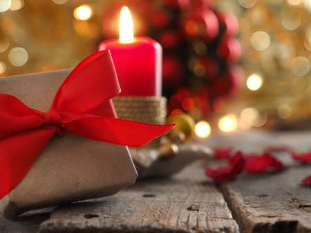 Seasonal background with red gift box and golden Christmas decorationの写真素材