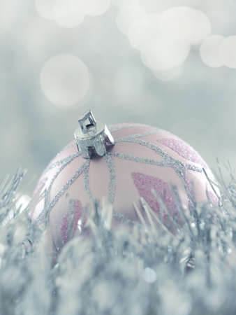 Single Christmas bauble with a silver garland and bokeh background, space for text or imageの写真素材